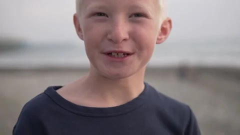 Close-up of the face of a beautiful blonde boy against the sea Video stock 142274154