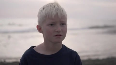Close-up of the face of a beautiful brooding baby boy blond against the sea Stock Footage 142540450