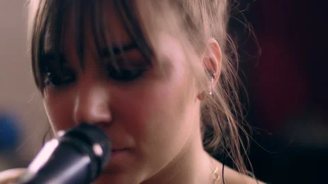 Close-up face of beautiful talented young European woman singing song on Stock Footage 131544236