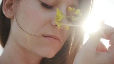 Close up face body attractive young woman stand in field hold play with flower Stock Footage 112752467