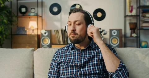 Close-up of the face of a boy with bearded dark hair listening to music on 스톡 동영상 200835784