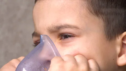 Close-up. The face of a boy with dark eyes and an inhaler mask 4K Stock Footage 126457104