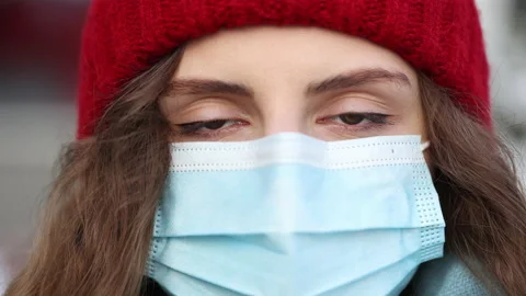 Close up of face calm serious curly haired woman wears protective mask to avoid Stock Footage 194432845