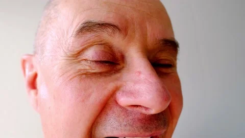 Close-up face of charismatic mature man 60 years old contorts mimic muscles,  Stock Footage 190010545