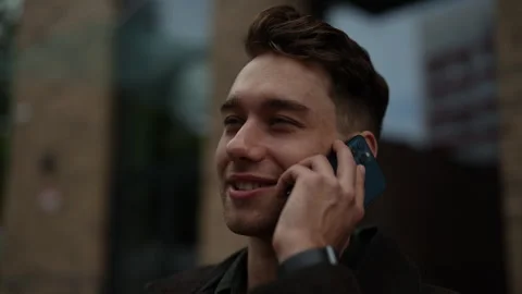 Close-up face of cheerful young man in casual clothing enjoying phone Stock Footage 296833358