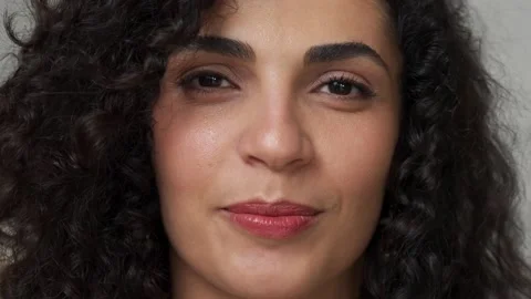Close-up of the face of a cheerful young mixed-race woman with curly hair in a Vídeos de archivo 164915759