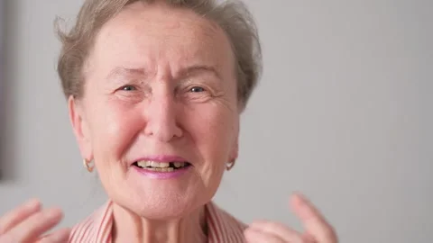A close-up of the face of a contented, smiling, dancing old woman Video stock 336027138