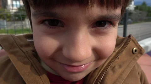 Close up face of cute boy looking on camera outdoors Stock Footage 136899588