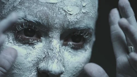 Close-up of the face of a dancing witch with creative makeup on a black backg Vídeos de archivo 133560892