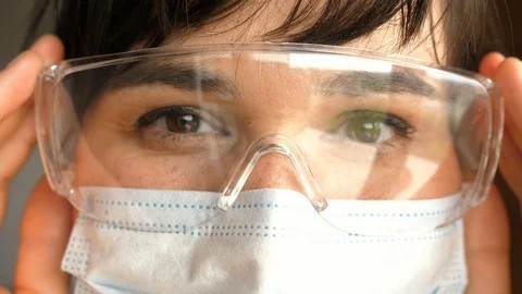 Close-up of face, eyes in mask protective glasses, portrait looking at camera Stock Footage 129666918