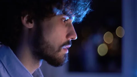 Close-up face of focused bearded man looking intently at monitor screen while Stock-Footage 146456673