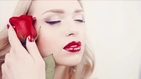 Close-up face of girl with red lips and red rose. Stock Footage 88449968