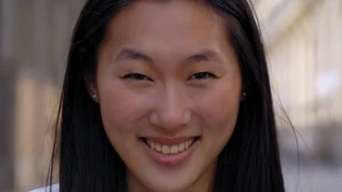 Close up face of happy beautiful young Asian woman happy smiling on street Stock Footage 247963393