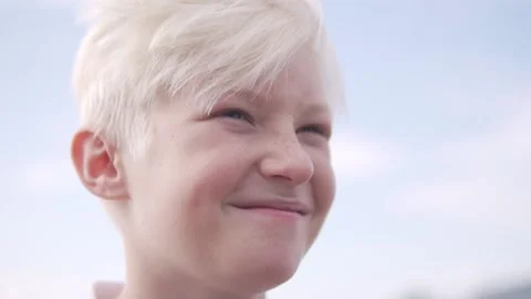 Close-up of the face, a happy blond boy against the sky Stock Footage 224735358