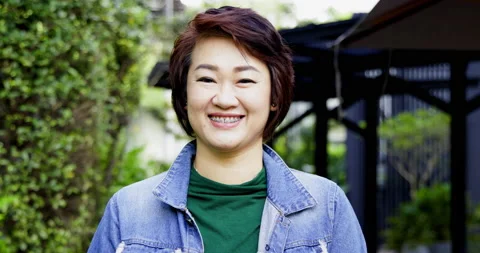 Close up face of happy middle-aged Asian woman with short hair smiling Stock Footage 163822715