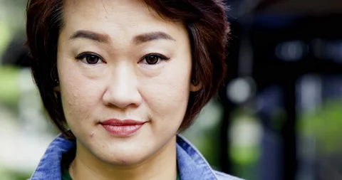 Close up face of happy middle-aged Asian woman with short hair smiling Stock Footage 163823553