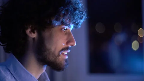 Close-up face of happy smiling bearded young man looking intently at computer Video stock 146456973