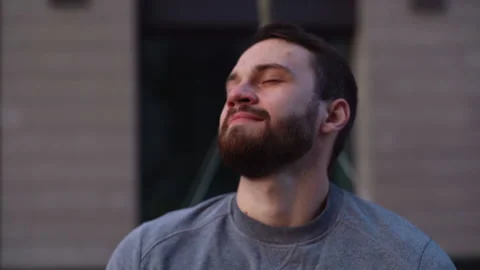 Close-up face of happy young man removing protective mask and doing deep breath Stock Footage 141156030