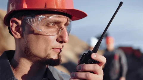 Close-up face male engineer in glasses and helmet talking using walkie talkie at Stock-Footage 108873994