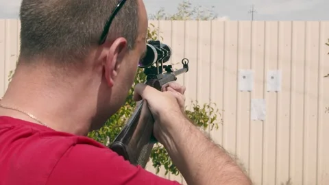 Close up of the face of a man aiming at an impromptu paper target while looking Video stock 137450942