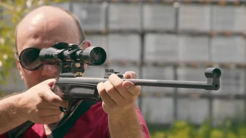 Close up of the face of a man aiming while looking into an optical rifle sight. Stock Footage 137382660