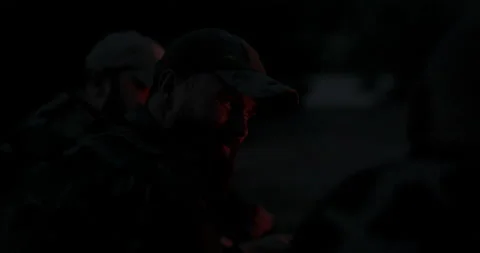 Close-up on face of man with beard in camouflage clothes and cap at night Stock Footage 169422754