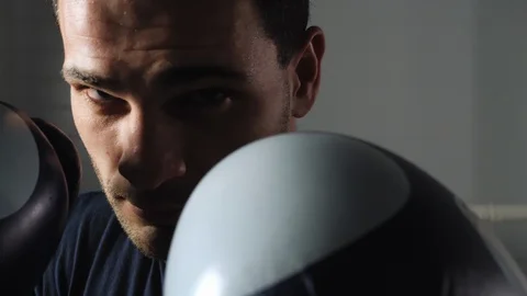 Close up face man boxer with boxing gloves front camera. Male fighter in boxing Video stock 128884922