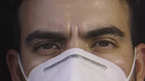 Close-up of face of man with brown eyes and who is wearing a face mask Stock Footage 132212672