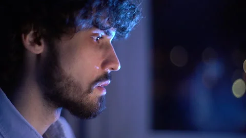 Close-up face of man looking intently at monitor screen while working on Stock Footage 146520643