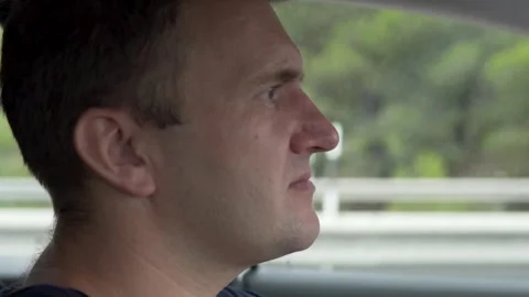 Close-up of a face, a man riding in a car in the summer Stock Footage 249660408