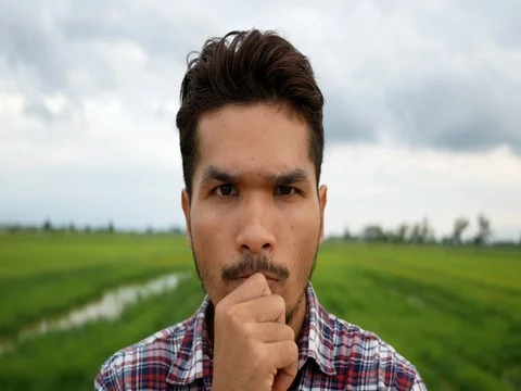 Close up face man thinking at the meadow. Stockbeeldmateriaal 77410116