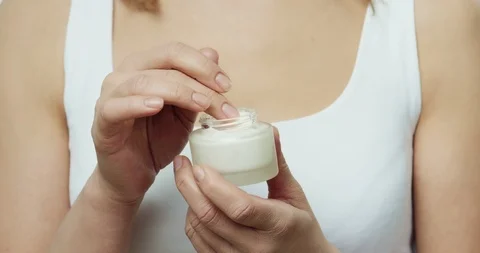 Close up of the face moisturizing cream in hands of pretty Caucasian woman, then Stock Footage 111519891