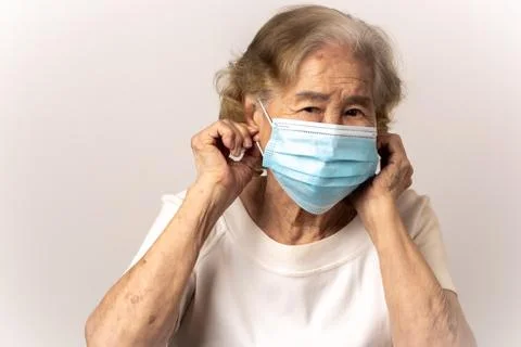 Close-up face of a old Asian woman wearing a mask Stock Photos