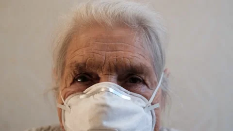 Close-up of the face of an old gray-haired woman in a mask respirator. Video stock 129566424