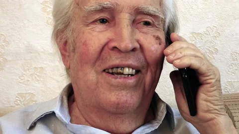 Close up face of old man. He is talking on the phone and smiling. Stock Footage 137129693