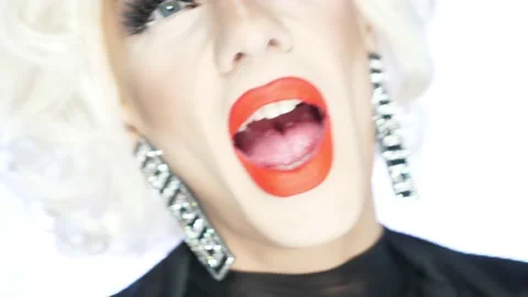 Close-up face of parody actor blonde with red lips, blue eyes and catchy makeup Stock Footage 166323965