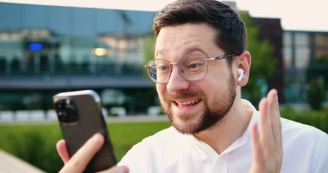 Close-up of face portrait cheerful young man in a white shirt standing on a city Stock Footage 333632161