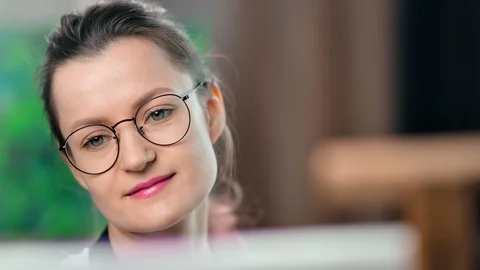 Close-up face of pretty enthusiastic young female painter in glasses enjoying Vídeos de archivo 109046294
