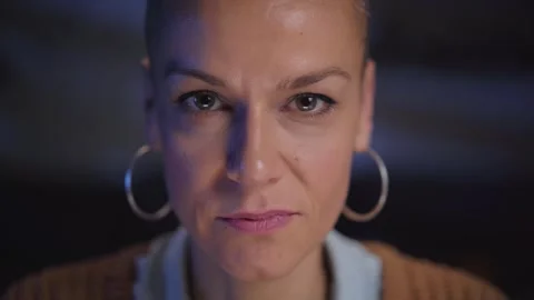 Close-up of face of pretty middle-aged woman with shaved hair looking up at Stock Footage 276672078