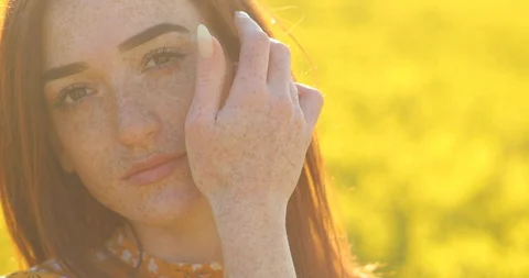 Close face of red-haired young woman with freckles on face and hands. girl on a Stock Footage 129372664