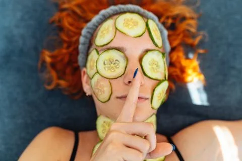 Close-up face red-haired young woman with round slices of cucumber, cucumbe.. Fotos Stock