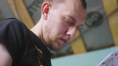 Close up of face repairman looking at instructions document or plan before Vídeo Stock 150723559