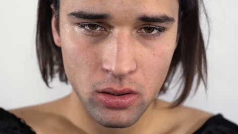 Close-up on the face of a sad guy with dripping mascara. Concept of femininity Stock Footage 102515340