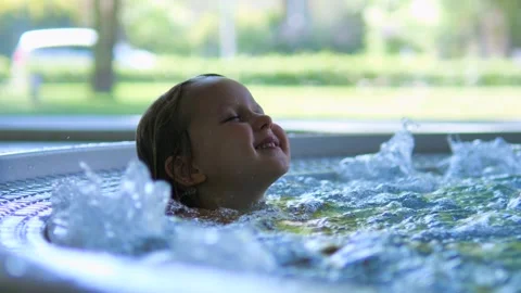Close-up face satisfied child bathing in water with bubbles in jacuzzi. Water Stock-Footage 275857874