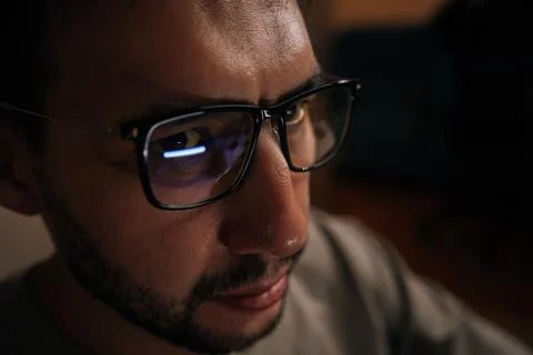 Close-up face of serious software developer wearing glasses, focused looking on Stock Photos