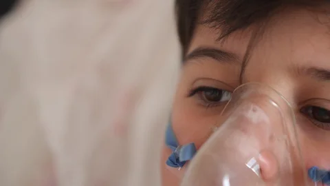 Close up face of sick child with sad eyes and breathing mask Stock-Footage 129603254