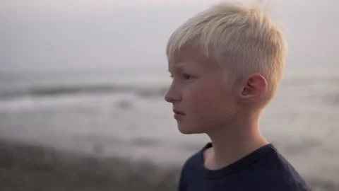 A close-up of the face on the side of a beautiful blonde boy in the evening by Stock Footage 142568636