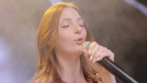 Close-up of the face of the singer with microphone on a black smoky background Video stock 194760317