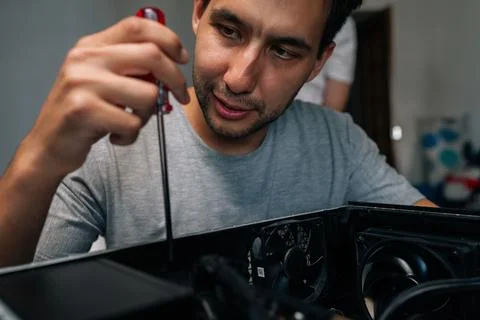 Close-up face of skilled technician disassembling desktop computer using Stock Photos