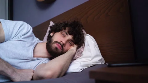 Close-up face of sleeping young man opening eyes, waking up and happy looking Stock-Footage 150052816
